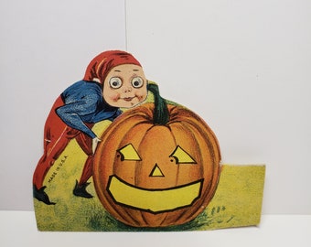 Unused die cut 1920's-30's Halloween place card elf or brownie pushing a large scared jack o'lantern