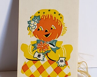 1930's unused colorful Dennison halloween bridge tally anthropomorphic lady jack o' lantern wearing a fancy hat  and dress with pantaloons