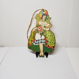 Brightly colored unused art deco die cut gold gilded 1920&#39;s-30&#39;s bridge tally deco lady in elaborate dress and bonnet with holds bouquet