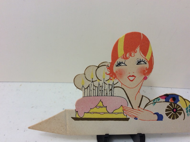 1920/'s unused gold gilded die cut Clark place card deco flapper lady next to pink and yellow Birthday cake with lit candles
