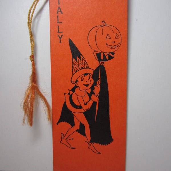 Art deco 1920's-30's bright orange colored Hallmark halloween bridge tally shows an pixie carrying a jack o'lantern on a stick with a cape