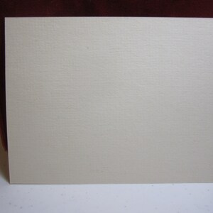 May include: A blank, off-white card with a slightly textured surface.
