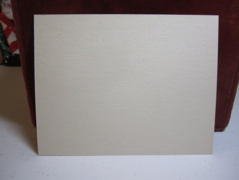 May include: A blank, off-white card with a slightly textured surface.