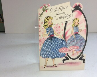 Darling unused 1950's die cut Buzza Cardozo birthday card colorful graphics of a young woman admiring her dress in a full length mirror