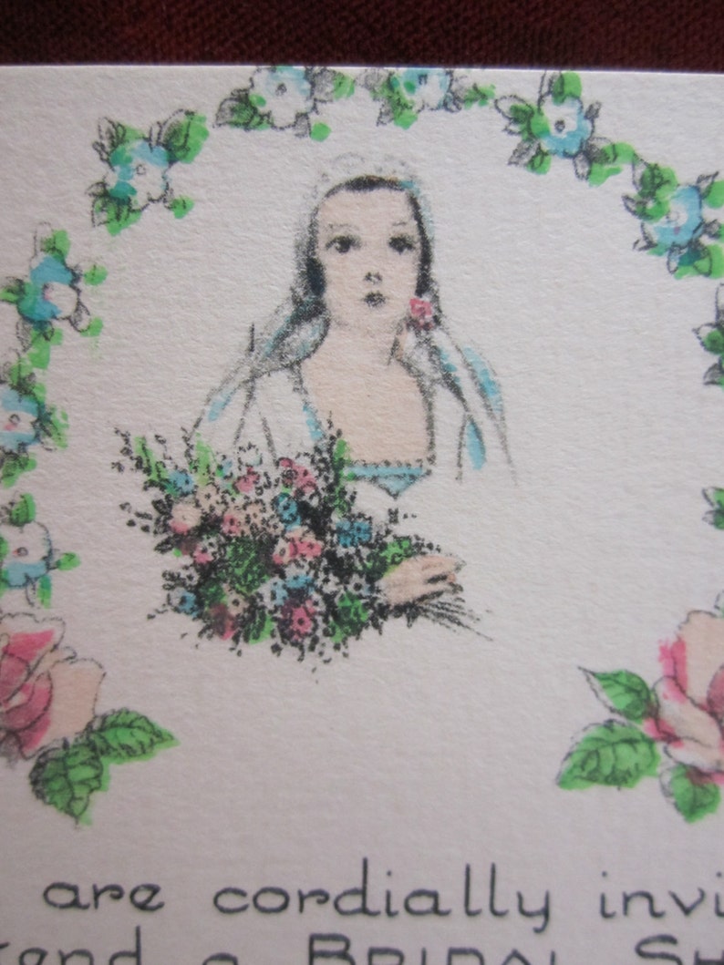 May include: A vintage bridal shower invitation with a hand-drawn illustration of a bride in a white dress holding a bouquet of flowers. The bride is surrounded by a wreath of blue and green flowers.