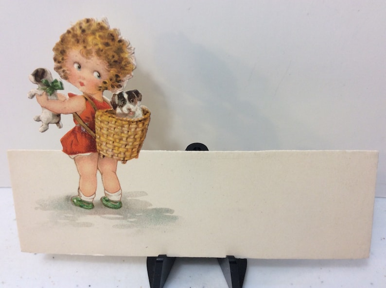 Adorable unused 1920/'s die cut Germany place card sweet little girl holds puppy looks over her shoulder at other puppy in basket on her back