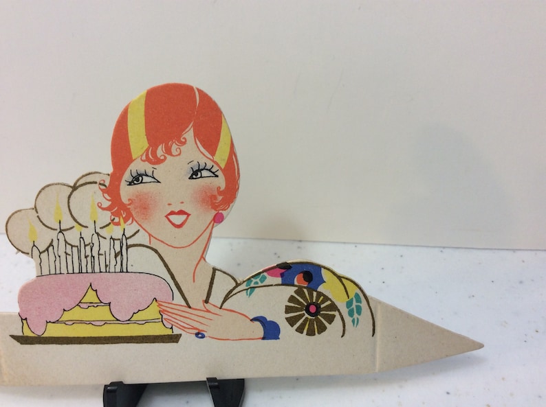 1920/'s unused gold gilded die cut Clark place card deco flapper lady next to pink and yellow Birthday cake with lit candles