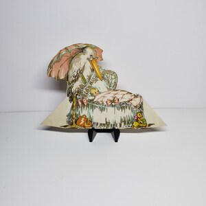 Unused vintage art deco 1920's-30's colorful gold gilded die cut Hallmark Stork and baby in bassinet baby shower place card stork