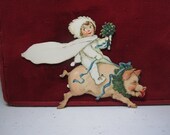 Unused 1920 39 s die cut Germany christmas place card snow baby holds mistletoe riding a pig with wreath around its neck and mushroom in mouth