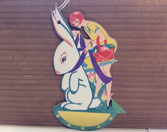 Gorgeous unused die cut colorful Easter themed 1920's Henderson bridge tally deco lady basket of eggs ties purple ribbon around large rabbit