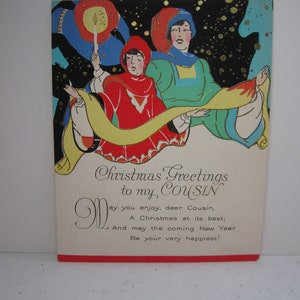 May include: Vintage Christmas card with an illustration of two figures in robes against a starry black background. The figures are holding a yellow scroll. The card reads "Christmas Greetings to my COUSIN".