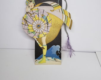 Gorgeous unused Art Deco 1920&#39;s-30&#39;s die cut gold gilded Buzza bridge tally Flapper in a swimsuit with elaborate deco parasol ocean wave