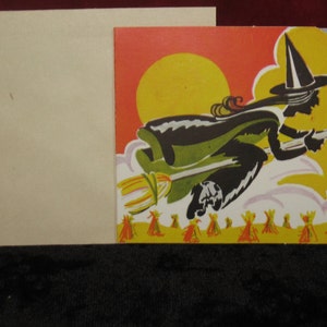 May include: A vintage Halloween card featuring a black silhouette of a witch flying on a broomstick against a yellow, orange, and gray background. The witch is wearing a black hat and dress and is holding a broom in her hand. The card has a cut-out design, with the witch and broom appearing to be flying out of the card.