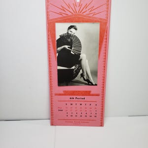 May include: A vintage calendar with a pink and red border. The calendar features a black and white photo of a person holding a fan. The calendar includes a June 1917 calendar and the text "6th Period".