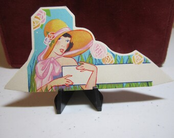 Colorful art deco 1930's unused die cut place card pretty lady in 1930's era hat in garden with stylized deco flowers
