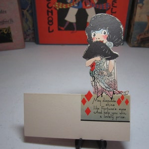 Fantastic 1923 art deco jazz age unused Buzza place card bridge tally elaborately dressed flapper with diamond jewelry and holding a fan