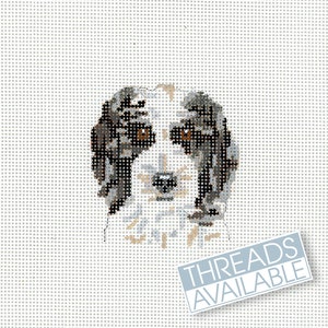 Peut inclure: Motif de point de croix représentant le visage d'un chien, utilisant des fils bruns, gris et blancs. Le chien a les yeux bruns et un museau clair. Les mots "THREADS AVAILABLE" sont imprimés sur une étiquette bleu clair.