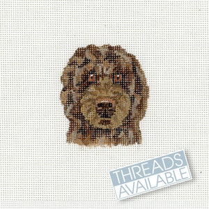 Peut inclure: Une toile de point de croix représentant un chien brun avec un pelage texturé et un regard attentif. La tête du chien est au centre sur un fond blanc. Le texte "THREADS AVAILABLE" est affiché dans un rectangle bleu clair.