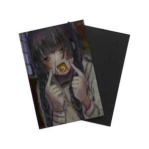 以下が含まれることがあります： 三つ編みの黒髪で明るい色のトップスを着たキャラクターのアニメ風イラストが描かれた長方形のマグネット。キャラクターは口に赤ちゃん用のおしゃぶりをくわえ、顔に赤い印があり、指で自分の頬を指差している。