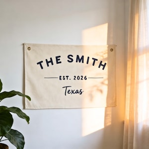 May include: A white ceramic mug with a black handle and the text "But First, Coffee" in a handwritten style. The mug is on a white surface. The mug is approximately 4 inches tall.