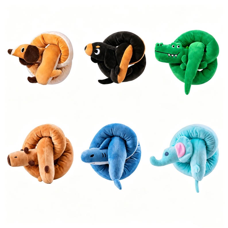 Op de afbeelding: Een verzameling van zes pluche dieren, elk opgerold in een cirkelvorm. De set bevat een beige en witte hond, een zwarte en beige hond, een groene krokodil, een bruine beer, een blauwe haai en een lichtblauwe olifant met roze oren.