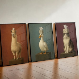 May include: Three framed wall art prints featuring a llama, a duck, and a cat. Each animal stands on a dark pedestal with a square tissue box balanced on its head. The backgrounds are solid colours in shades of terracotta, teal, and deep plum.