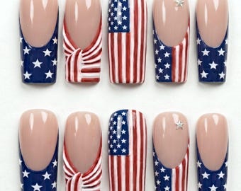 Può includere: Un set di dieci unghie finte con un tema patriottico nei colori rosso, bianco e blu. I disegni includono strisce della bandiera americana, sezioni blu con stelle bianche, una texture annodata su due unghie e piccoli accenti a forma di stella.