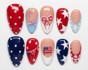Può includere: Un set di dieci unghie finte a forma di mandorla con disegni patriottici. La collezione include unghie rosse e blu a pois bianchi, french manicure con fuochi d'artificio dipinti, fiocchi, bandiere e stelle bianche su sfondo rosso o blu.