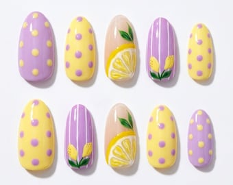 Può includere: Un set di dieci unghie finte a forma di mandorla con vari design, tra cui pois gialli su base color lavanda, pois color lavanda su base gialla, strisce verticali color lavanda con motivi di limoni e fette di limone gialle.