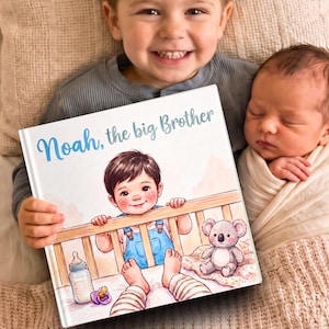 Peut inclure: Un livre à couverture rigide intitulé Noah, the big Brother présentant une illustration à l'aquarelle d'un enfant en salopette bleue debout dans un lit à barreaux avec un biberon, une tétine violette et une peluche koala grise.