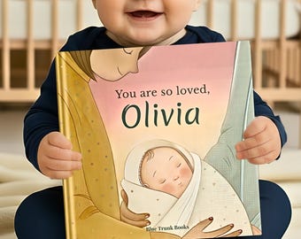 Könnte beinhalten: Ein Kinderbuch mit festem Einband und dem Titel You are so loved, Olivia, das eine Illustration einer Person zeigt, die einen Säugling in Windeln hält. Der Einband hat einen rosa-goldenen Farbverlauf und den Text Blue Trunk Books.