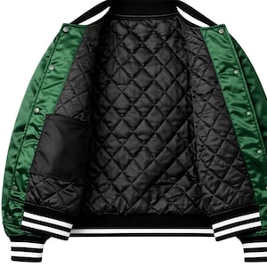 Puede incluir: Chaqueta bomber de sat&eacute;n verde con forro acolchado negro. La chaqueta tiene cuello y pu&ntilde;os negros con rayas blancas. Cuenta con un bolsillo interior y cierre de botones.