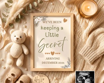 May include: A framed announcement with the text "We've been keeping a Little Secret ARRIVING DECEMBER 2026" is surrounded by baby items. A small teddy bear, baby shoes, and a "Hello Baby" sign are also present.