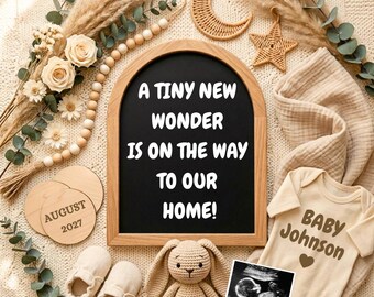 May include: An arched wooden chalkboard with the white text A TINY NEW WONDER IS ON THE WAY TO OUR HOME, accompanied by a beige baby bodysuit labeled BABY JOHNSON, a crochet rabbit, two wooden discs marked AUGUST 2027, and a sonogram image.