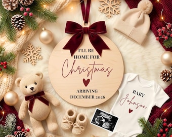 May include: A festive Christmas-themed announcement. A wooden ornament with the text "I'll be home for Christmas, arriving December 2026" is surrounded by a teddy bear, baby booties, a onesie, and an ultrasound image. The color scheme includes cream, burgundy, and brown.