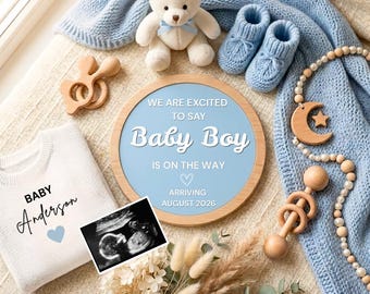 May include: A light blue knitted blanket, a cream teddy bear with a blue ribbon, blue knitted booties, a wooden rattle, a wooden moon and star bead garland, a white sweater with "BABY Anderson" text, and a round sign stating "BABY BOY IS ON THE WAY" with an ultrasound photo.