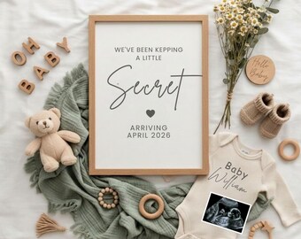 May include: A framed announcement with the text "We've been keeping a little secret, arriving April 2026." A beige onesie with "Baby William" and an ultrasound image. Includes a teddy bear, baby booties, and wooden accents.