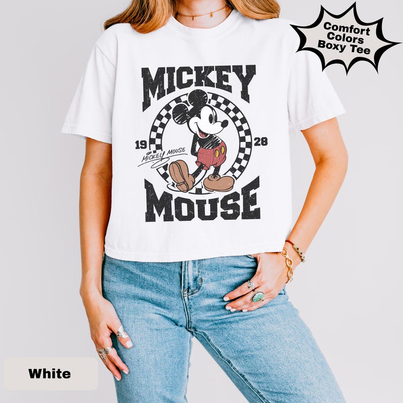 May include: White t-shirt featuring a classic Mickey Mouse graphic. The design includes the words "Mickey Mouse" and the year "1928". The shirt is a Comfort Colors Boxy Tee.