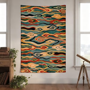 May include: A rectangular wall tapestry with a cloud-like pattern in teal, orange, red, and black. The design features swirling shapes resembling clouds or waves. The tapestry is hanging on a white wall near a window.
