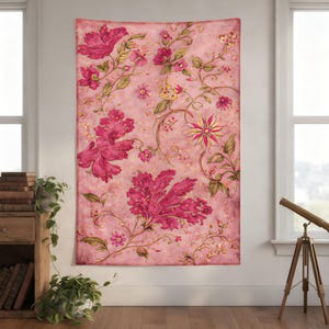 Pode incluir: Uma tapeçaria floral rosa com um design vintage. A tapeçaria apresenta grandes flores rosa estilizadas com detalhes dourados e folhas verdes sobre um fundo rosa suave. O design inclui vinhas intrincadas e elementos florais menores.