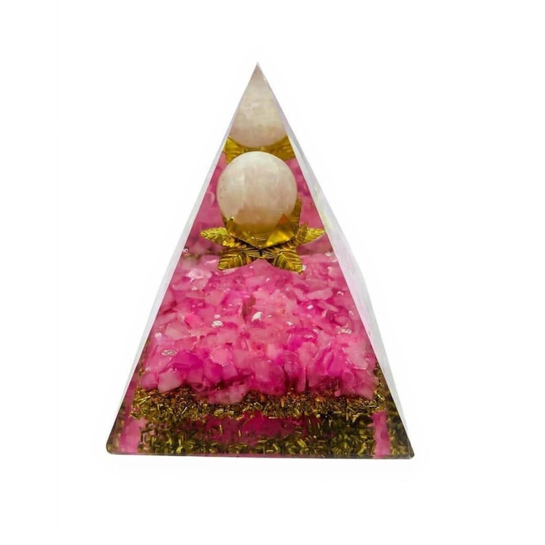 The Rose Quartz Pyramid placed on a nightstand next to a lamp. The soft pink hues suggest a calming atmosphere, perfect for promoting better sleep, emotional clarity, and a sense of security in a bedroom setting.