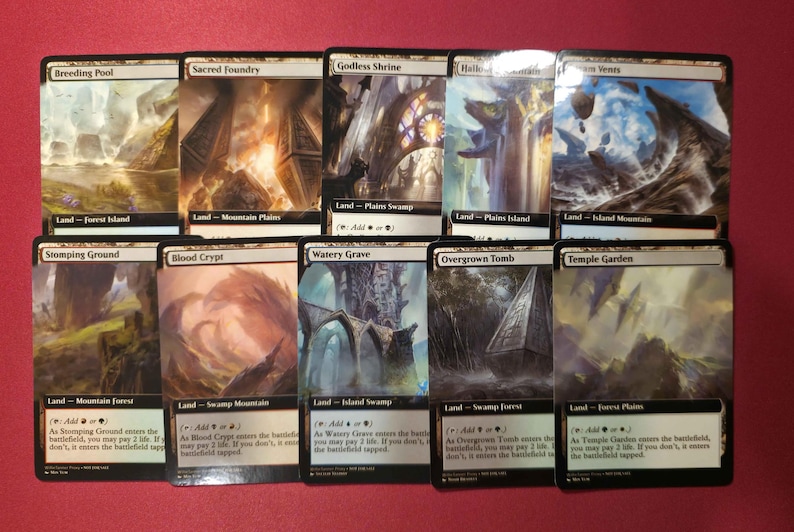 Pode incluir: Uma cole&ccedil;&atilde;o de dez cartas colecion&aacute;veis de Magic: The Gathering. Cada carta apresenta obras de arte &uacute;nicas retratando paisagens e estruturas. As cartas s&atilde;o rotuladas com nomes como "Breeding Pool" e "Sacred Foundry."