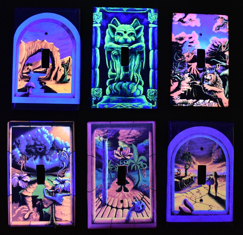 May include: Six unique, hand-painted light switch covers with surreal, glowing artwork. Each cover features a different design, including a gargoyle, a lion, and fantastical landscapes, all in vibrant neon colors. The covers are rectangular with a cutout for the switch.