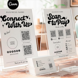 May include: Two acrylic signs with black text that read "Connect With Us" and "Scan to Pay." Each sign has QR codes and social media icons. A stack of business cards sits in front.
