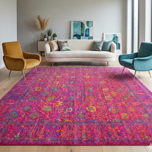 Puede incluir: Una alfombra rectangular grande con una base de color rosa fucsia vibrante y un intrincado patrón floral y geométrico multicolor en tonos amarillo, azul verdoso, azul y naranja, rematada con un borde decorativo detallado.