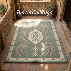 Op de afbeelding: Een rechthoekig vloerkleed met een centraal geometrisch ontwerp en boomachtige patronen. Het vloerkleed heeft een lichtgroen veld met een beige rand en accenten. De tekst "BetterCallRugs" is zichtbaar.