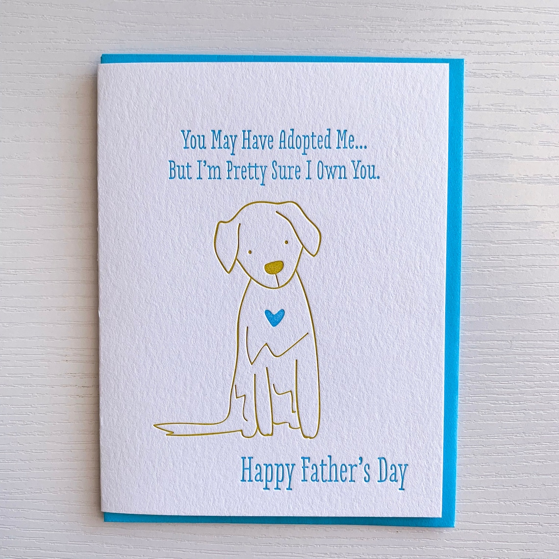 white and blue card with gold outline of dog