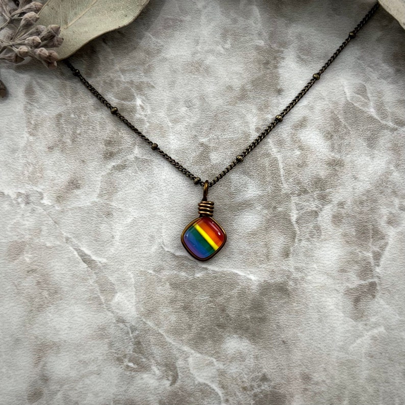 Forward facing front view of the tiny rainbow necklace with an antique brass satellite chain.