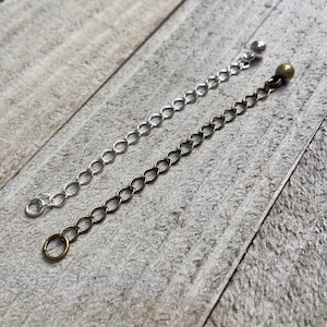 May include: Two chain extenders, one silver and one gold, with jump rings and ball closures.