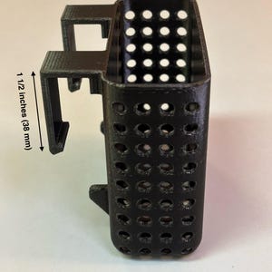 May include: Black, rectangular container with a perforated design. The container is 1 inch (25 mm) wide and 1 1/2 inches (38 mm) tall. The text "20 gallon tall" is printed at the bottom.